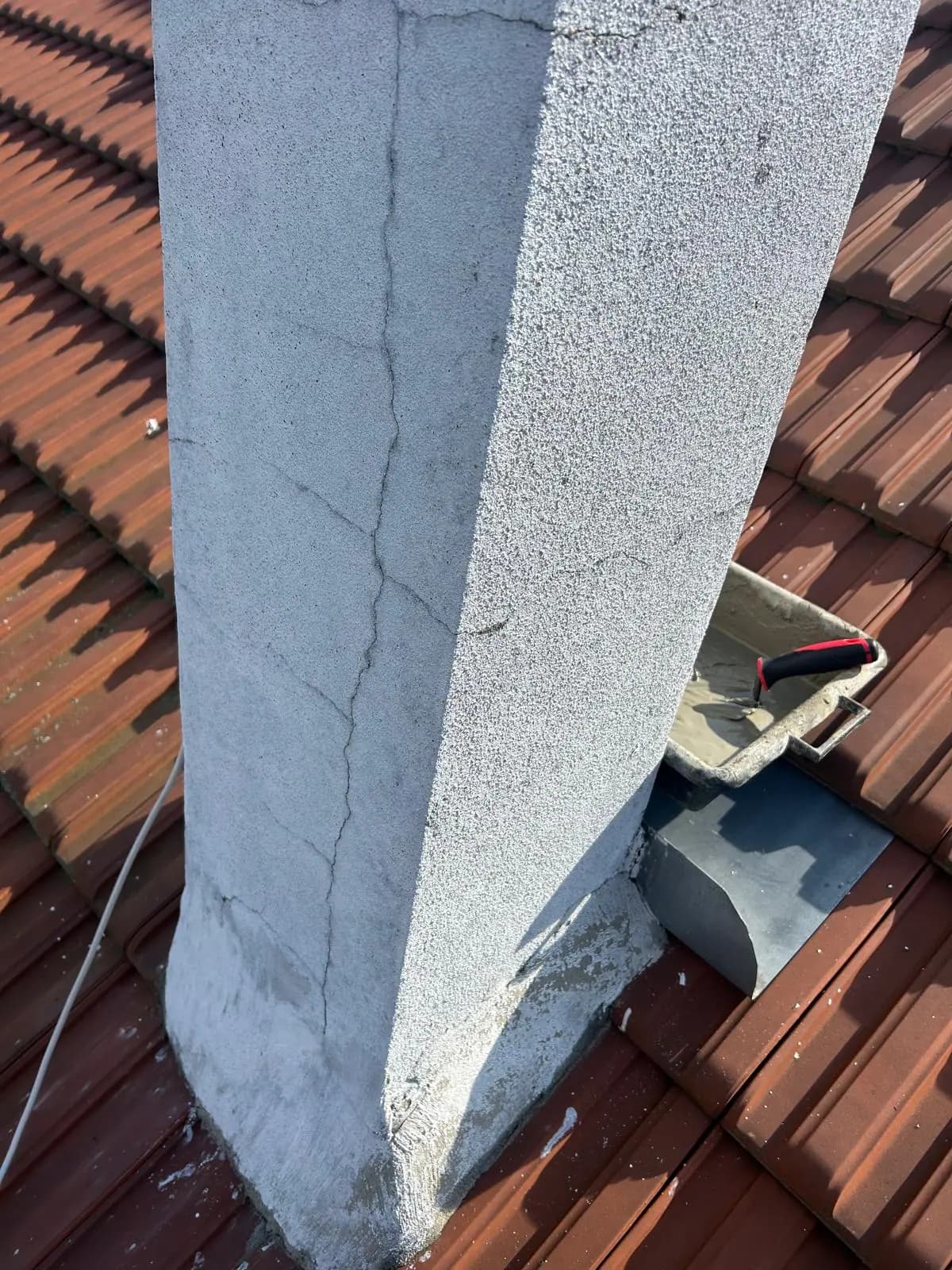 Souche de cheminée en cours d'enduit, avec un solin de zinc neuf en pied de souche — RW Couvreur