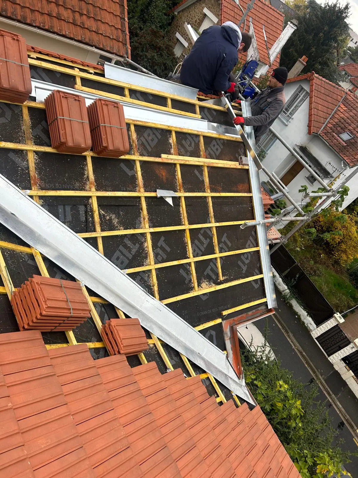 Versant en réfection vu de dessus : écran de sous-toiture, liteaunage neuf et bandes de rive en aluminium — RW Couvreur